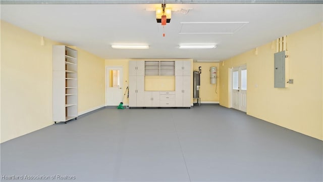 garage featuring water heater, electric panel, and a garage door opener