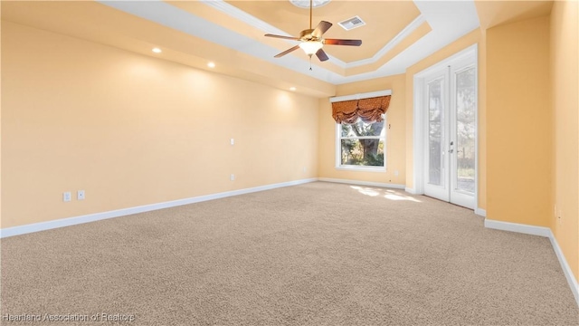 carpeted empty room with recessed lighting, a ceiling fan, visible vents, baseboards, and a raised ceiling