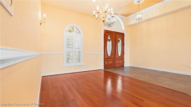 foyer with a chandelier, wood finished floors, and baseboards