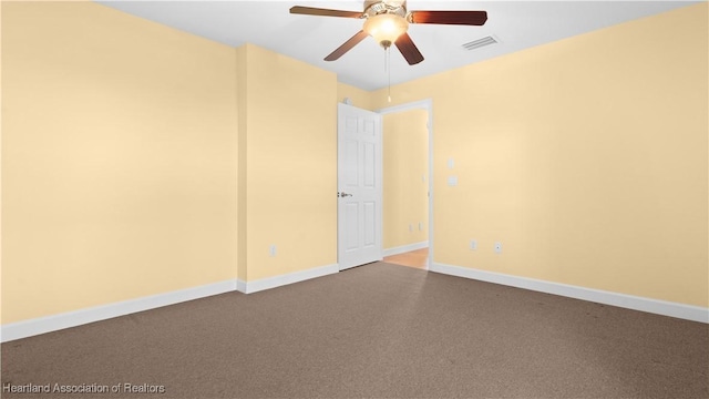 unfurnished room with carpet floors, baseboards, visible vents, and ceiling fan