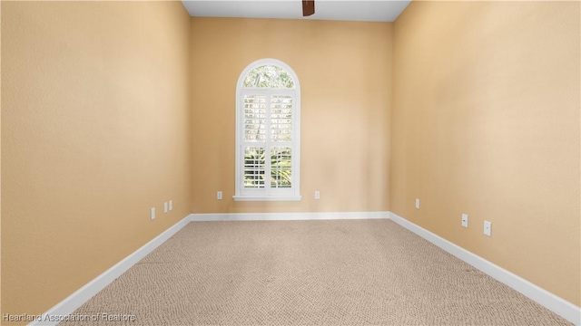 unfurnished room with carpet floors, baseboards, and a ceiling fan