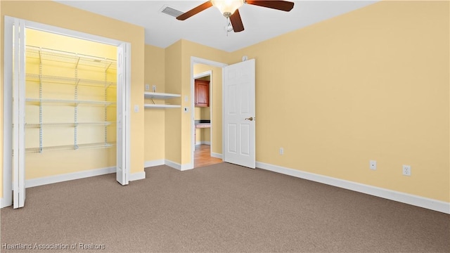 unfurnished bedroom featuring carpet floors, baseboards, visible vents, and ceiling fan