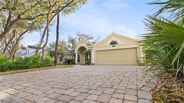 view of front of house featuring a garage, decorative driveway, and stucco siding