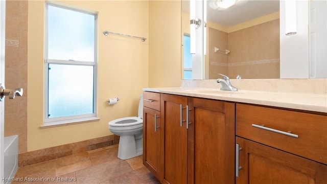 bathroom with toilet, tile patterned flooring, vanity, and baseboards