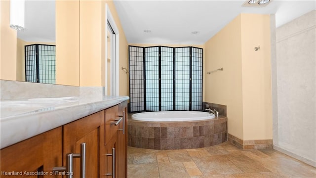 bathroom featuring a garden tub and vanity