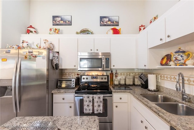 kitchen with stainless steel appliances, white cabinetry, and sink