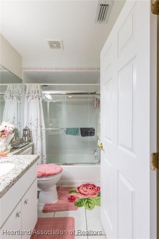 full bathroom with tile patterned flooring, enclosed tub / shower combo, vanity, and toilet