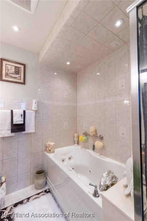 bathroom featuring a bathing tub and tile walls