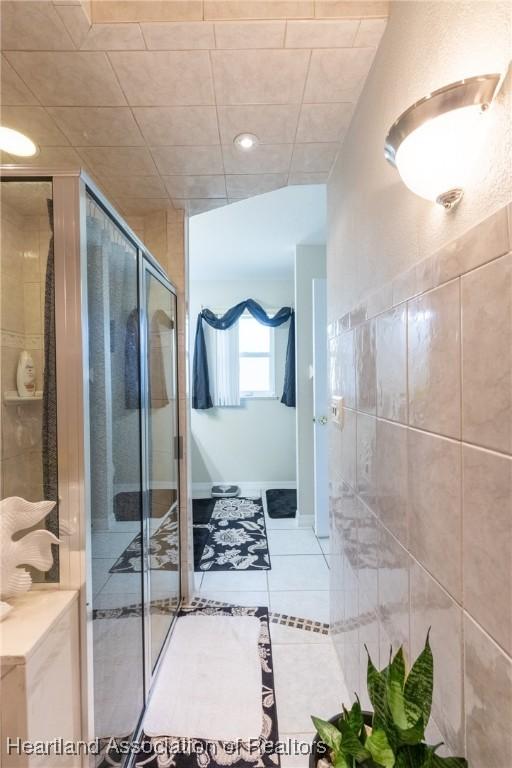 bathroom with tile patterned floors and a shower with door