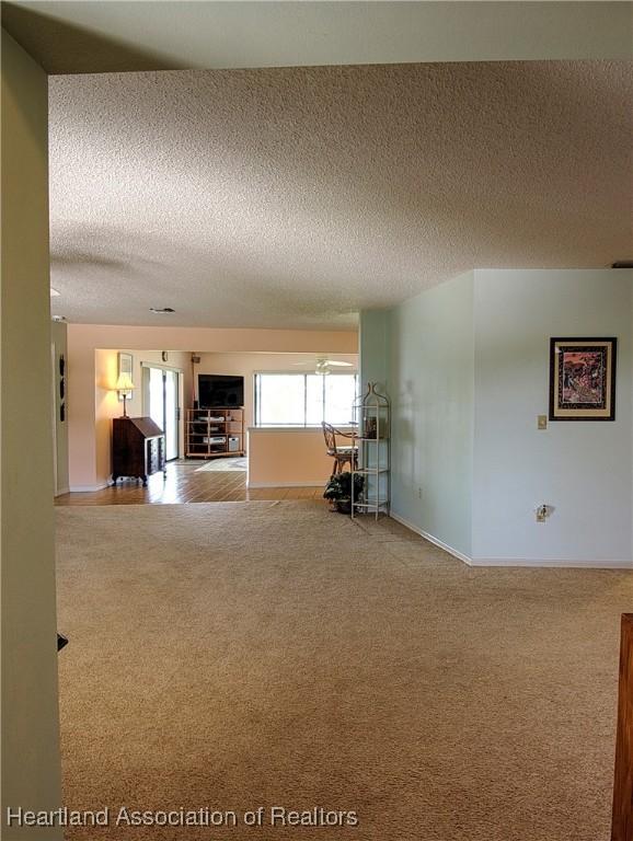 interior space with a textured ceiling and baseboards