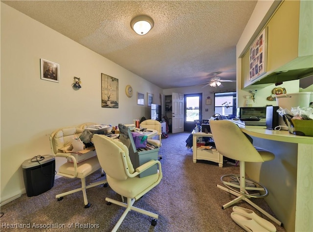 living room with ceiling fan, a textured ceiling, and dark colored carpet