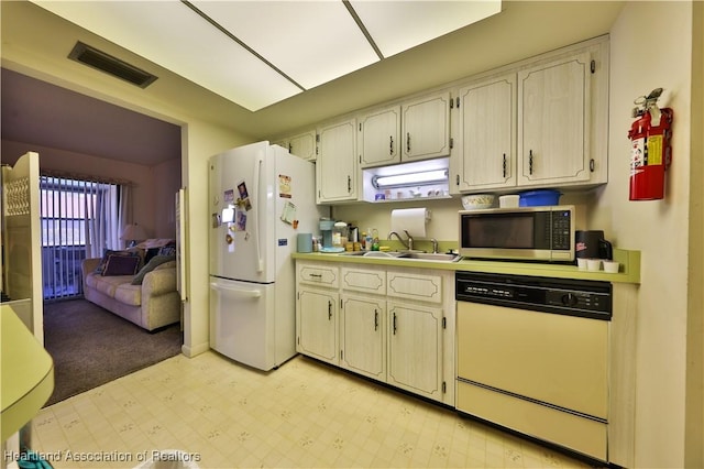 kitchen featuring sink, white appliances, and cream cabinets