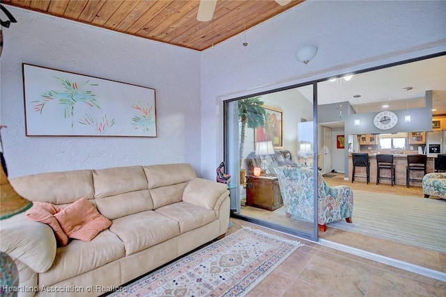 living room with ceiling fan, lofted ceiling, and wood ceiling