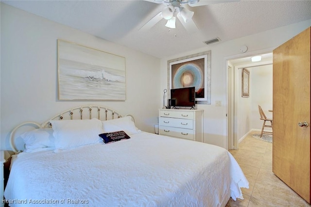 bedroom with ceiling fan, a textured ceiling, and light tile patterned flooring