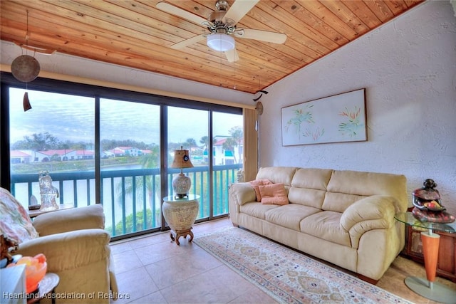 living room with ceiling fan, wooden ceiling, light tile patterned floors, and lofted ceiling