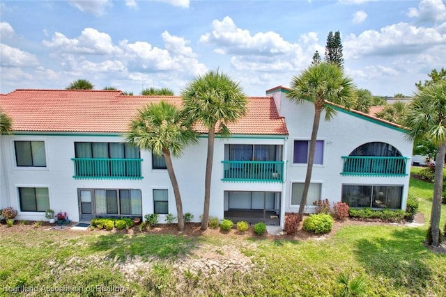 4915 Casablanca Cir Unit H22, Sebring, FL 33870 - rear view of house with a tiled roof, stucco siding, and a lawn