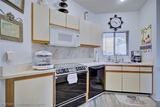 4915 Casablanca Cir Unit H22, Sebring, FL 33870 - kitchen with black appliances, a sink, light countertops, tasteful backsplash, and a textured ceiling