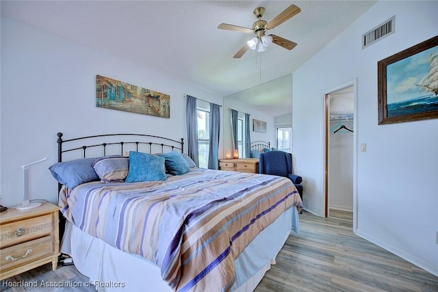 4915 Casablanca Cir Unit H22, Sebring, FL 33870 - bedroom with lofted ceiling, a spacious closet, wood finished floors, a ceiling fan, and baseboards