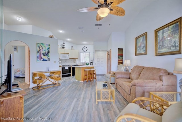 4915 Casablanca Cir Unit H22, Sebring, FL 33870 - living room with lofted ceiling, ceiling fan, light wood-style floors, arched walkways, and baseboards