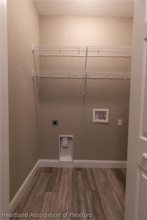 laundry room with hookup for an electric dryer, dark hardwood / wood-style floors, a textured ceiling, and washer hookup