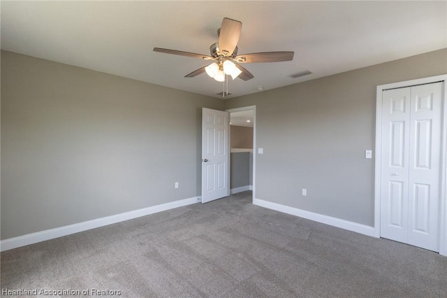 unfurnished bedroom with carpet, ceiling fan, and a closet