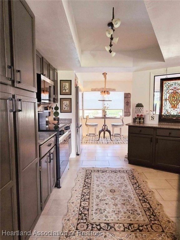 2919 Summertree Dr, Sebring, FL 33872 - kitchen featuring a raised ceiling, appliances with stainless steel finishes, light tile patterned floors, and a notable chandelier
