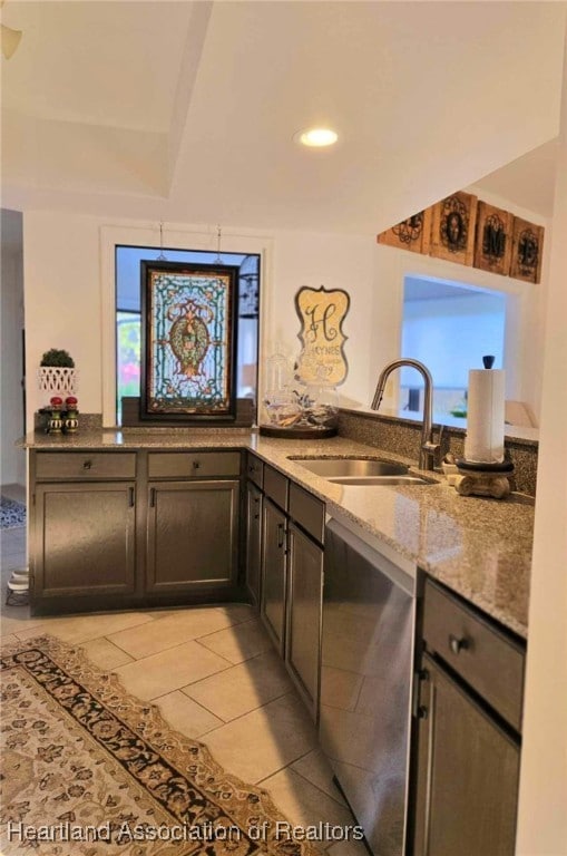 2919 Summertree Dr, Sebring, FL 33872 - kitchen with light tile patterned flooring, light stone counters, a sink, and dishwasher