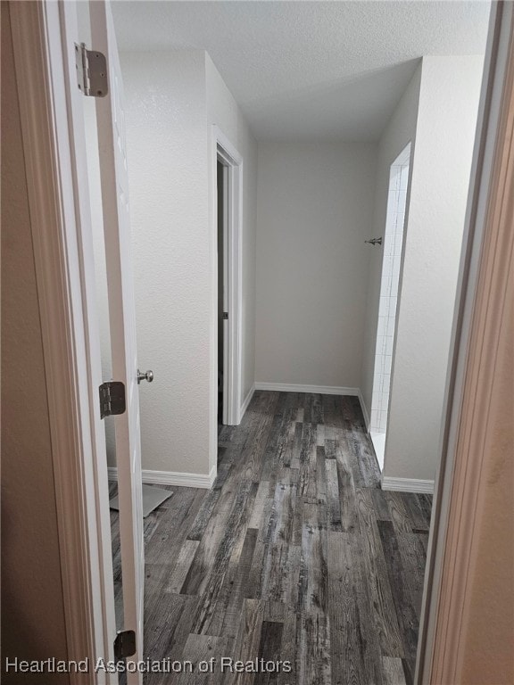 565 Stephens Rd, Wauchula, FL 33873 - corridor with a textured ceiling, wood finished floors, and baseboards