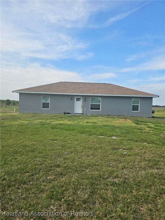 565 Stephens Rd, Wauchula, FL 33873 - back of house featuring stucco siding and a lawn