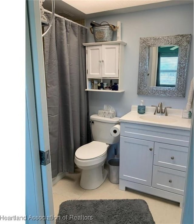 bathroom with walk in shower, vanity, toilet, and tile patterned flooring