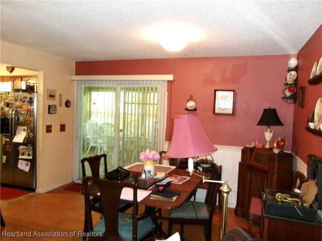 1618 Roberta Ave, Sebring, FL 33870 - dining area featuring wood finished floors, a textured ceiling, and a wainscoted wall