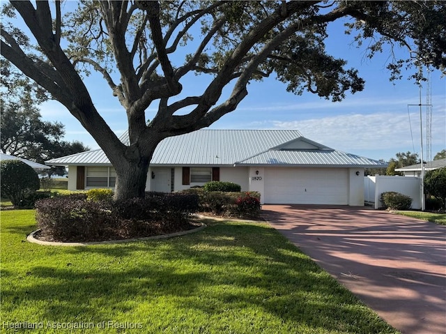 ranch-style house featuring a garage and a front lawn