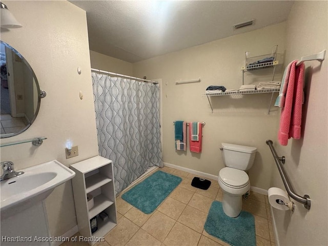 bathroom featuring toilet, walk in shower, and tile patterned floors