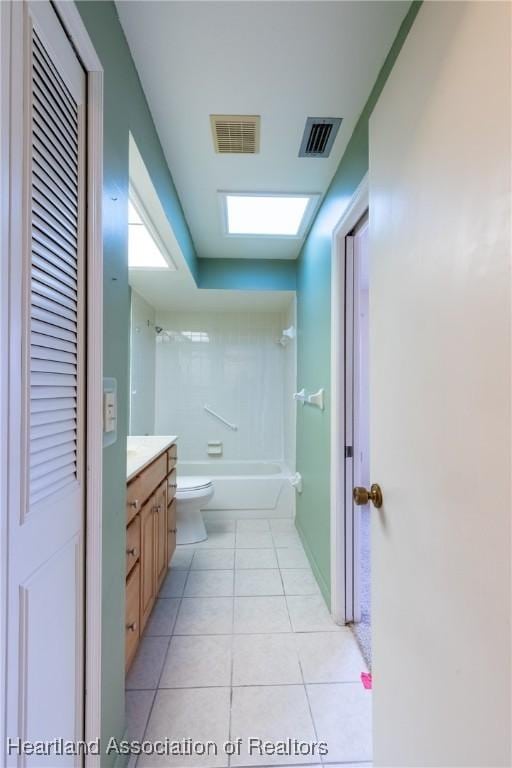 full bathroom with a skylight, tile patterned floors, tub / shower combination, vanity, and toilet