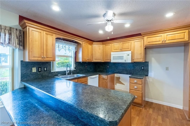 kitchen featuring a textured ceiling, light hardwood / wood-style floors, white appliances, and sink