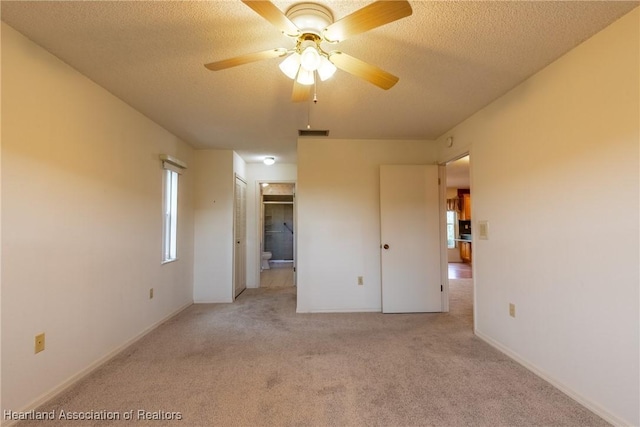 unfurnished room with light carpet, a textured ceiling, plenty of natural light, and ceiling fan