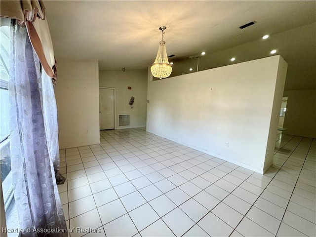 empty room with lofted ceiling, light tile patterned flooring, and visible vents