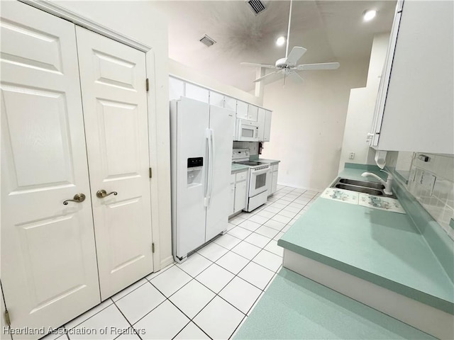 kitchen featuring white appliances, visible vents, white cabinets, and a sink