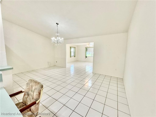 unfurnished room with light tile patterned floors and a chandelier