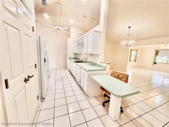 kitchen with light tile patterned floors, light countertops, white appliances, and white cabinets