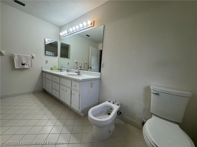 bathroom featuring a textured ceiling, toilet, a sink, baseboards, and tile patterned floors