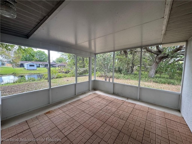 unfurnished sunroom featuring a water view