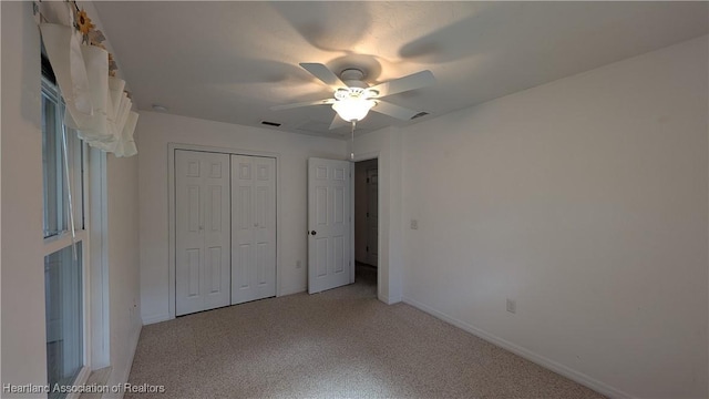 unfurnished bedroom featuring light carpet, baseboards, visible vents, ceiling fan, and a closet