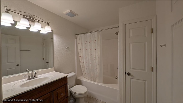 full bathroom with a textured wall, toilet, shower / bath combo with shower curtain, vanity, and tile patterned flooring