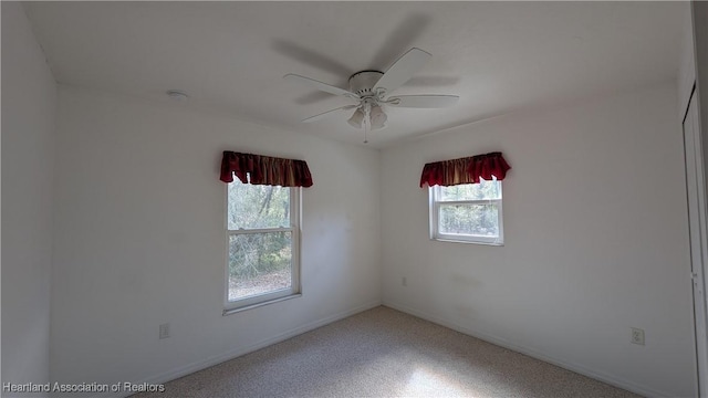 unfurnished room with a ceiling fan and baseboards