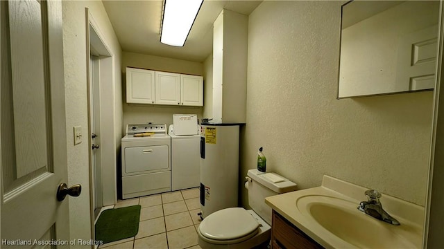 bathroom featuring water heater, toilet, vanity, separate washer and dryer, and tile patterned floors