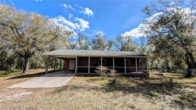 view of front of house featuring an attached carport, a sunroom, and concrete driveway