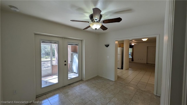 doorway to outside featuring baseboards, light tile patterned flooring, a ceiling fan, and french doors