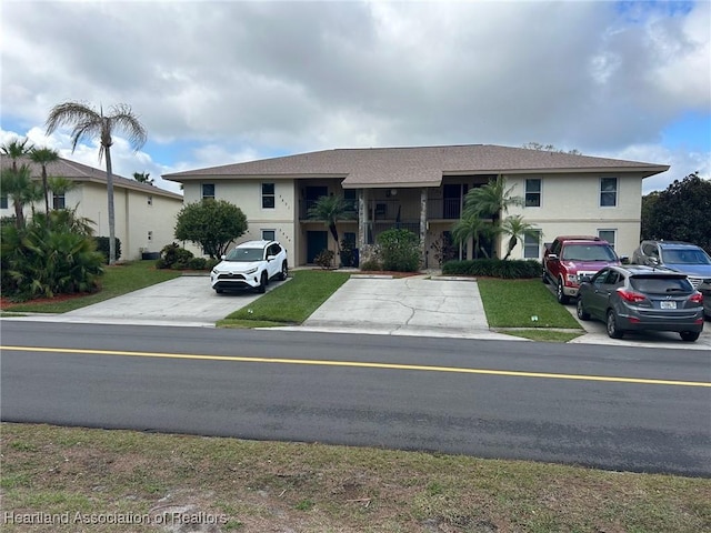 view of front of house with a front lawn and stucco siding