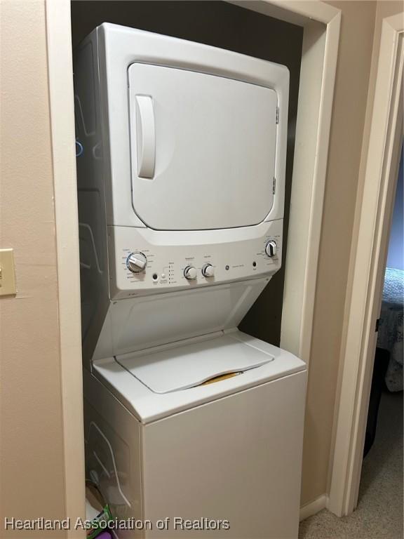 washroom featuring laundry area and stacked washing maching and dryer